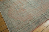 Distressed Oushak rug corner showcasing even wear, blush, and charcoal tones.