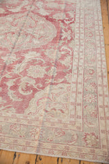 Corner of a distressed Turkish carpet showing faded red floral vinery and low, even wear.