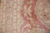 Evenly worn pile of a vintage Turkish carpet showing faded red floral details and foundation.