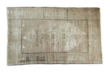 Distressed vintage Oushak rug, central geometric medallion, pale beige, blush, and charcoal tones.