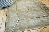Distressed vintage Oushak rug corner, showing faded pile, subtle abrashes, and fringed edge.