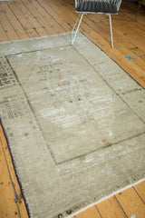 Pale beige abrashes at the lower corner of a vintage Oushak carpet with white fringe.