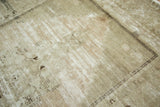 Distressed vintage Oushak rug showing pale beige, faded blush abrashes and charcoal geometric outline.