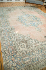 Softly worn distressed Oushak carpet with pale blush field and sky blue fern filled cartouches.