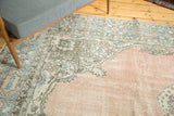 Corner detail of distressed vintage Oushak rug, pale blush field, blue and coffee cartouche border.