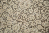 Distressed vintage Sivas carpet detail: even wear, light foundation, muted beige and chocolate brown motifs.