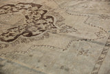 Corner spandrel detail showing its contrasting brown outline on the distressed Oushak rug.
