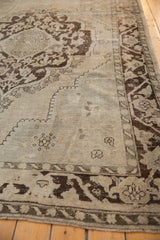 A vintage Oushak rug corner showing its spandrel overlay and heavy textural abrashes.