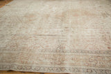 Soft pile texture of distressed vintage Oushak, with faded floral motifs in ivory and sand.