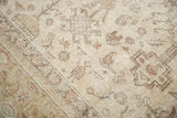 Distressed vintage Oushak rug's muted ivory field with abstract folk art motifs.