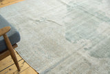 Distressed vintage Oushak carpet corner with faded seafoam green and ivory texture.