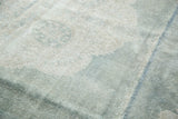 Distressed texture of a vintage Oushak rug, showing foundation and pale seafoam green.