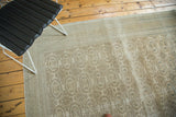 Kaisary carpet with intricate arrowed borders and pale coffee brown gul motifs.