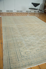 Distressed vintage Kaisary carpet corner, with dusty teal arrowed border and faded gul motifs.