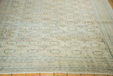Secured end of vintage distressed Kaisary carpet, showing pale gul motifs and arrowed minor border.