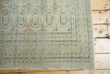 Distressed vintage Kaisary rug corner detail, highlighting dusty teal arrowed borders and faded gul motifs.