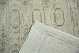 Vintage distressed Kaisary carpet folded to reveal hand-knotted construction and pale gul motifs.