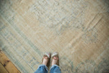 Textured vintage distressed Oushak rug, featuring soft peach, ivory, and faded seafoam patterns.