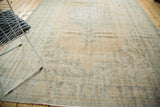 Distressed vintage Oushak rug pile showing faded peach, ivory, and seafoam green hues.