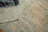 Distressed texture and faded peach, sea foam green motifs on a vintage Oushak rug.
