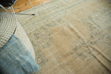 Distressed vintage Oushak rug texture, showing faded peach, blue patterns and even wear.