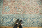 Distressed vintage Tabriz carpet, faded denim blue border and pale blush field.
