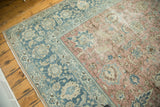 Vintage Tabriz rug corner with distressed blush field and faded denim palmette border.