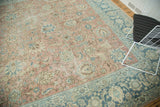 Pale blush beige distressed field with worn palmette motifs and faded denim blue border.