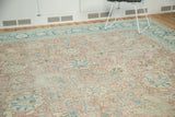 Distressed vintage Tabriz rug with pale blush, ivory, and faded blue palmette pattern.
