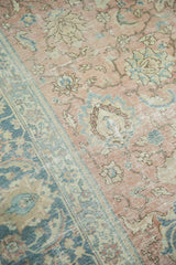 Distressed Tabriz carpet detail: faded blush field with ivory palmettes and denim blue border.
