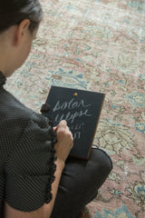 Distressed vintage Tabriz carpet texture with faded blush, ivory, and sea foam green palmettes.