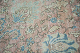 Distressed vintage Tabriz rug with faded blush, denim blue palmettes and soft leaves.