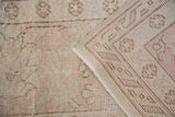 Distressed ivory Oushak pile with blush pink and brown hand-knotted foundation.