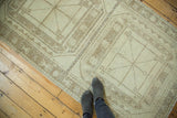 Distressed vintage Oushak runner with geometric medallion pattern in pale coffee brown and ivory.