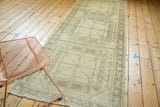 Distressed Oushak runner's geometric gul motif with faint ivory and pale coffee brown tones.