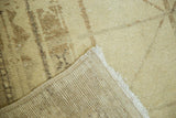Distressed ivory and beige pile texture and hand-knotted foundation of the Oushak runner.