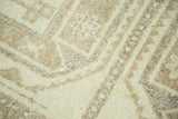 Textured pile showing geometric pattern in ivory, sand, and muted coffee brown tones.