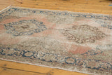 Dusty rose distressed Oushak runner, navy medallion, geometric border, visible foundation.
