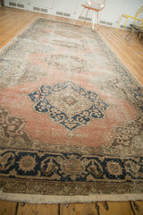Distressed Turkish Oushak runner border with navy palmettes, rose field, and fringe.