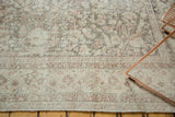 Distressed Sivas carpet detail: muted floral pattern and even wear showing texture, in ivory.