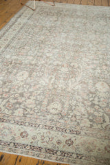 Distressed border of a vintage Sivas carpet, featuring faded palmettes and scrolling floral vines.