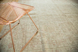Distressed vintage Oushak rug's faded floral vinery in ivory, pale terracotta, and blush.