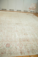 Distressed Oushak rug close-up: even wear revealing faded ivory, blush, and green floral details.