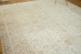 Distressed vintage Oushak rug showing even wear with muted ivory, blush, and sea foam green floral motifs.
