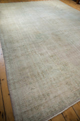 Distressed vintage Oushak carpet corner with exposed foundation, secured side, and subtle ivory green hues.