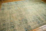 Distressed vintage Persian Meshed rug, faded pale gold and sky blue floral motifs.