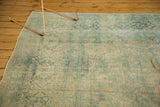 Distressed texture of the vintage Meshed rug, showing faded sea foam green and pale gold floral cartouches.