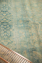 Faded pale blue and antique ivory floral patterns on distressed vintage Meshed rug.