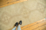 Distressed ivory and beige Oushak runner highlighting subtle medallion motifs.