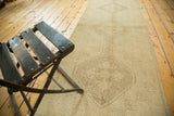 Muted ivory and beige distressed Oushak runner with subtle medallion pattern.